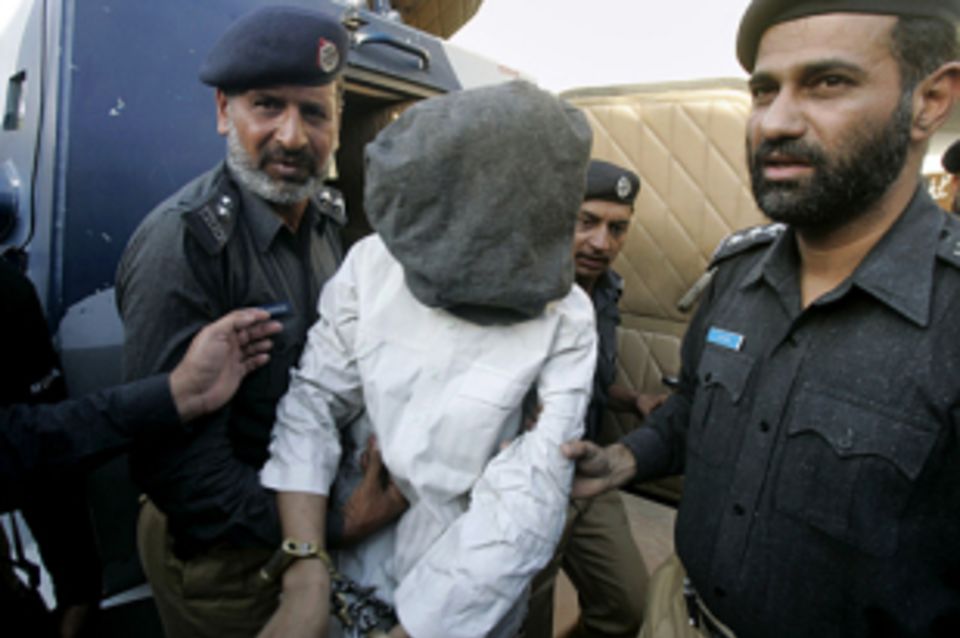 The suspect, identified as Zubair, appeared at the news conference with a blanket over his head to hide his identity