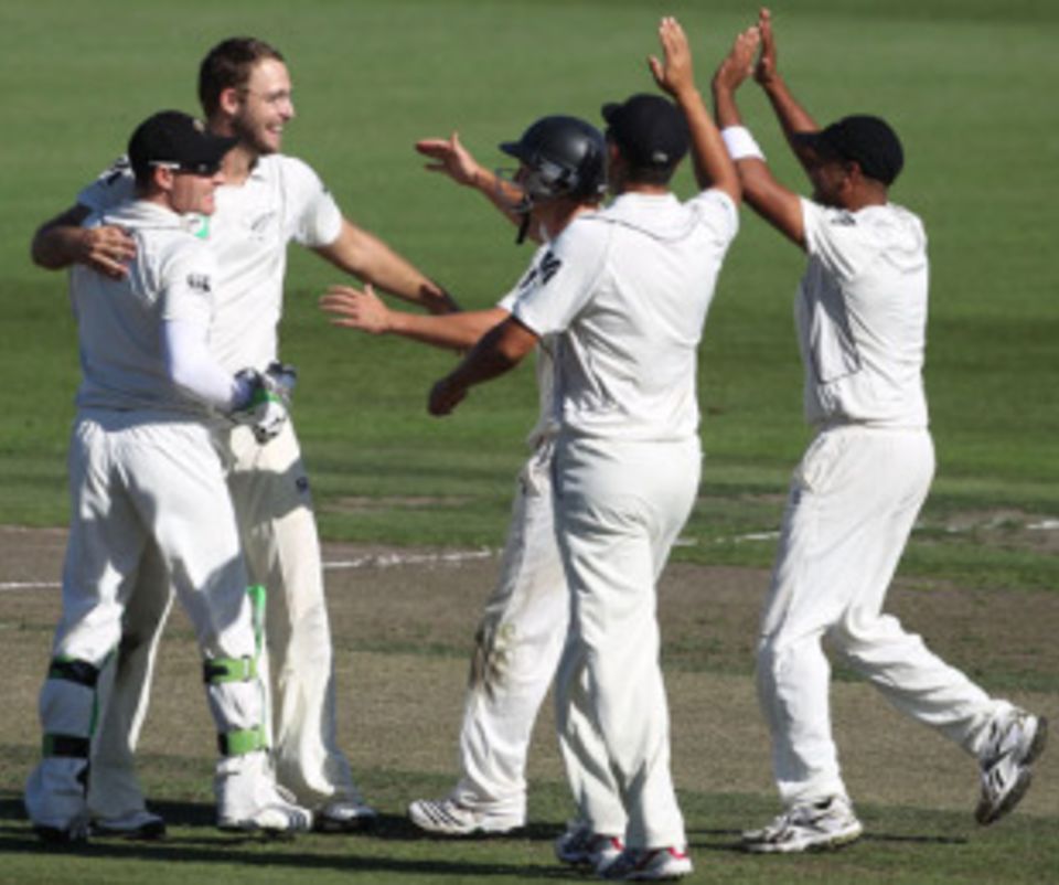 Man of the moment: Daniel Vettori is surrounded by his team-mates on the way to an important four-wicket haul