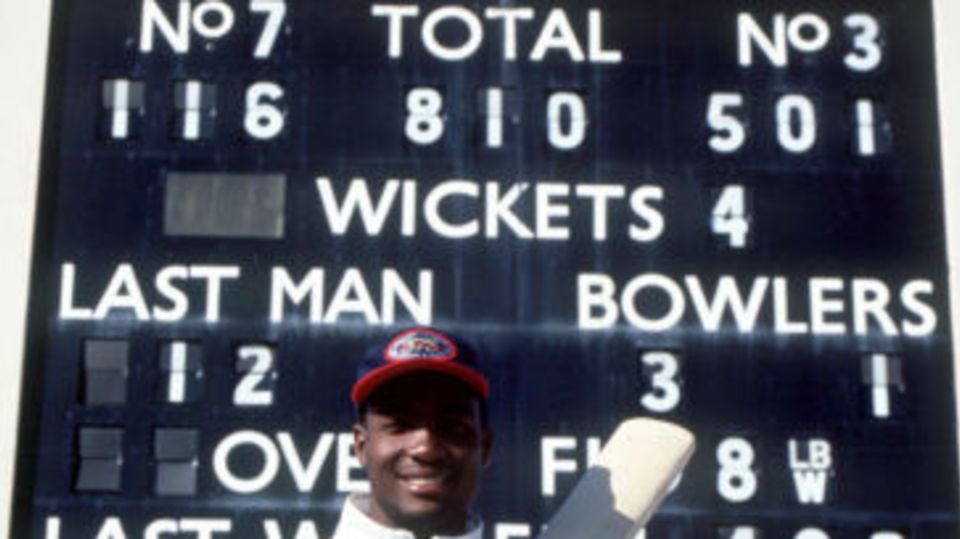 Brian Lara poses next to the scoreboard that shows his record-breaking 501