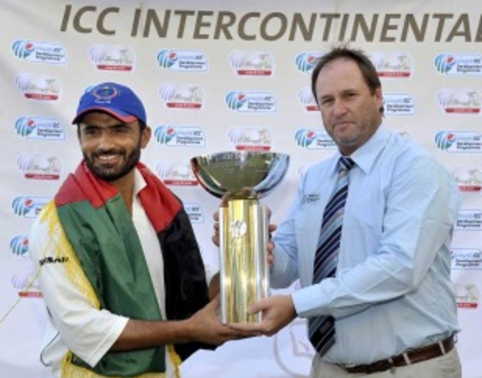 Nawroz Mangal is handed the trophy by ICC's Richard Done after Afghanistan's victory over Scotland
