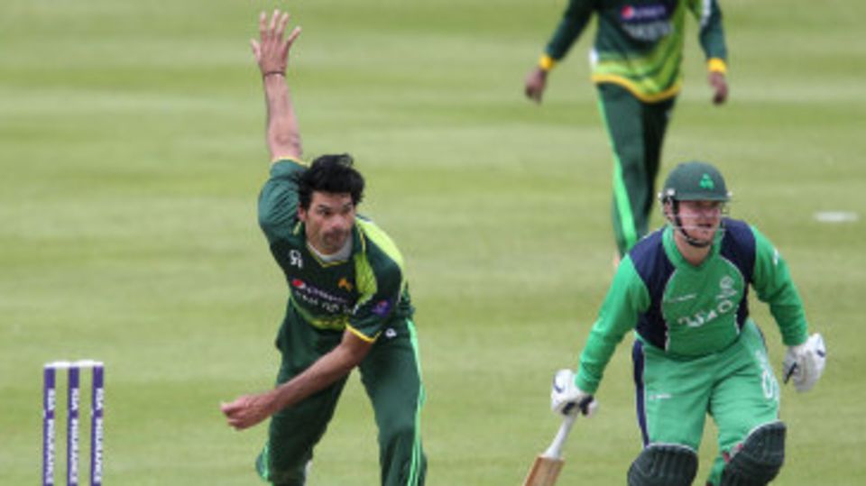 Mohammad Irfan bowls a delivery while Paul Stirling looks on