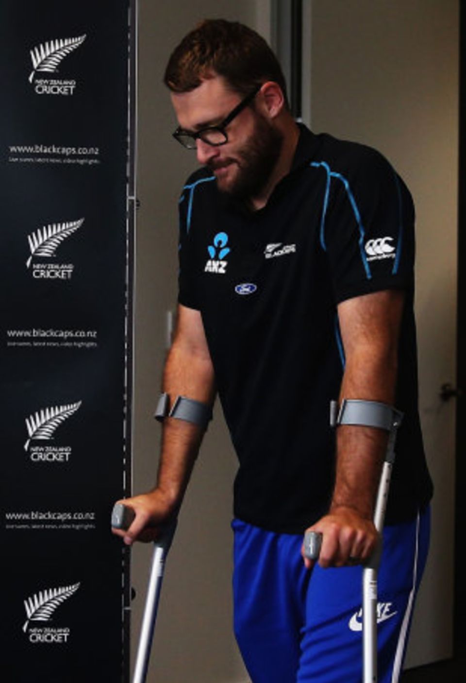 Daniel Vettori arrives at a press conference in Auckland on crutches