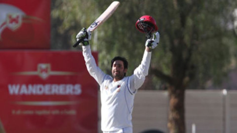 Asghar Stanikzai raises his bat after reaching his century