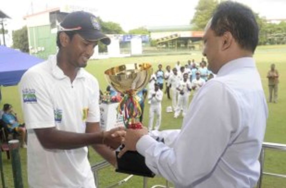 Dimuth Karunaratne receives the SLC Four-day tri-series trophy on behalf of the Board XI
