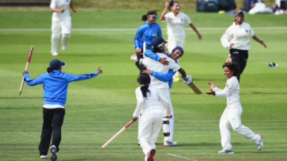 The India players run to the pitch to celebrate their win