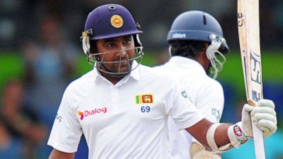 Mahela Jayawardene raises his bat after reaching fifty