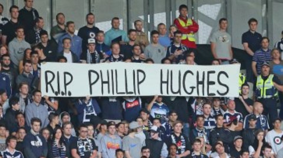 Spectators at an A-League game in Melbourne pay their respects to Phillip Hughes