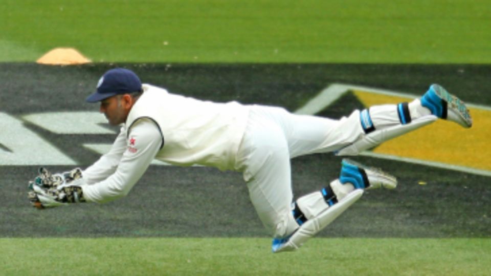 MS Dhoni dives to claim a catch from Joe Burns