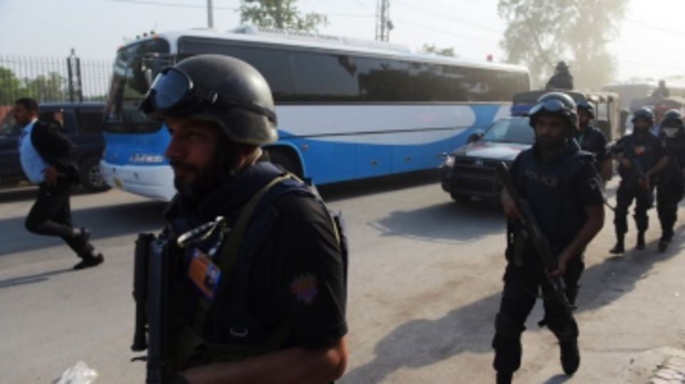 The team buses of the Pakistan and Zimbabwe teams flanked by policemen