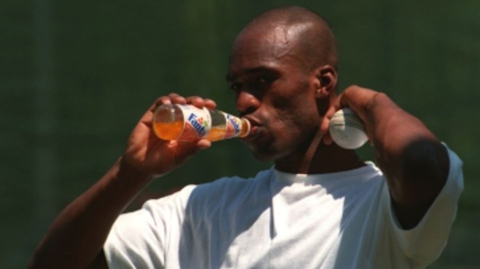 Chris Lewis takes a sip from a soft drink