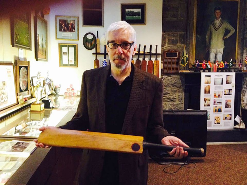 The "weather-beaten old warrior": the author holds a bat owned by Don Bradman which found its way to a university in Pennsylvania