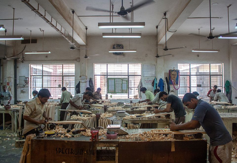 Workers handcraft bats on the SG factory shop floor