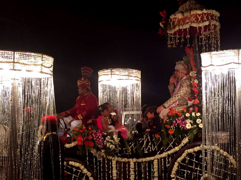 A wedding procession drives through a street in Delhi