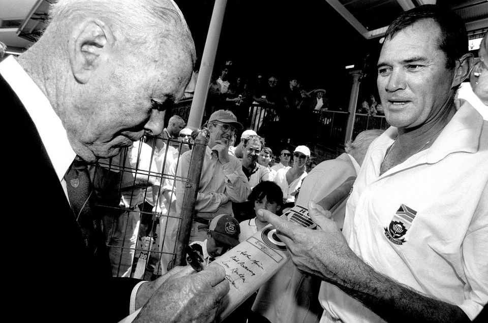 Blessings from an Invincible: Bill Brown signs the bat of a man who become the only player ever to pass 50 in Tests batting at eight, nine, 10 and 11