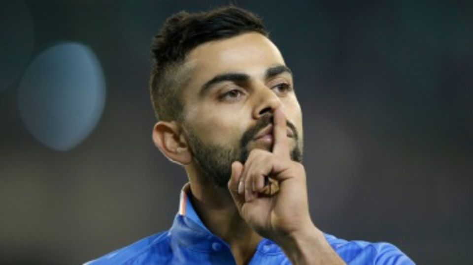 Virat Kohli gestures to the crowd while fielding