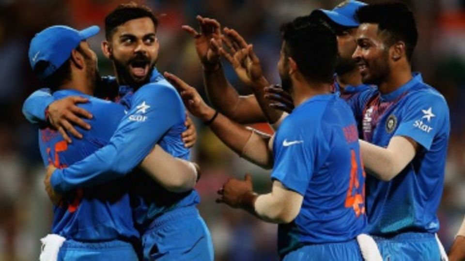 Virat Kohli is mobbed by his team-mates after getting the wicket of Johnson Charles