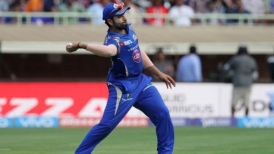 Mumbai Indians captain Rohit Sharma prepares to throw the ball