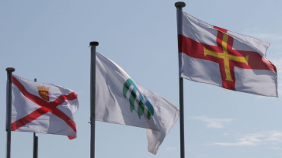 Jersey (left) and Guernsey (right) flags fly high at the start of play