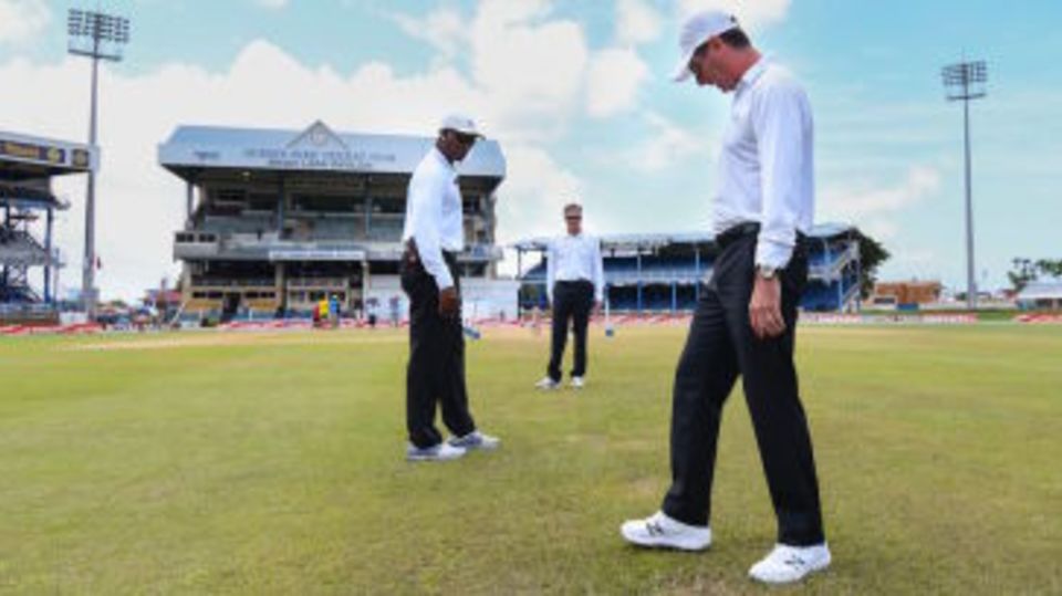 The umpires inspect the outfield at Queen's Park Oval