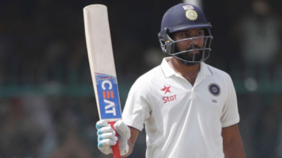Rohit Sharma raises his bat after reaching fifty
