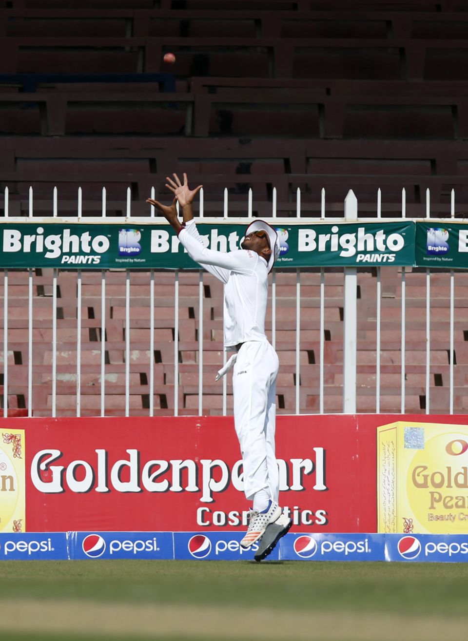 Roston Chase jumps backwards on the boundary line to prevent Mohammad Amir's shot from going for six