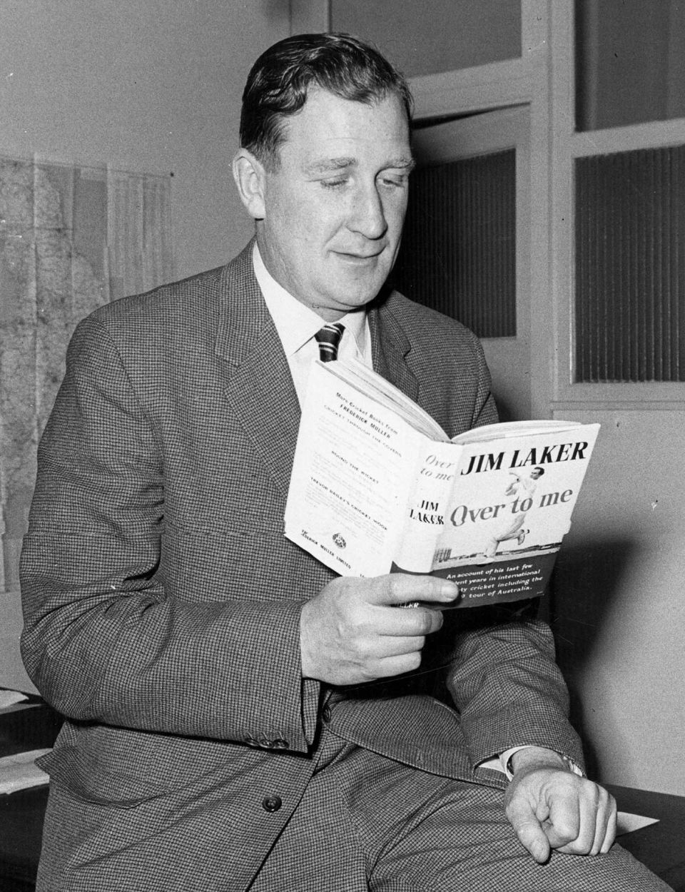 A ripping good yarn: Jim Laker reads his book <i>Over to Me</i>, in 1960