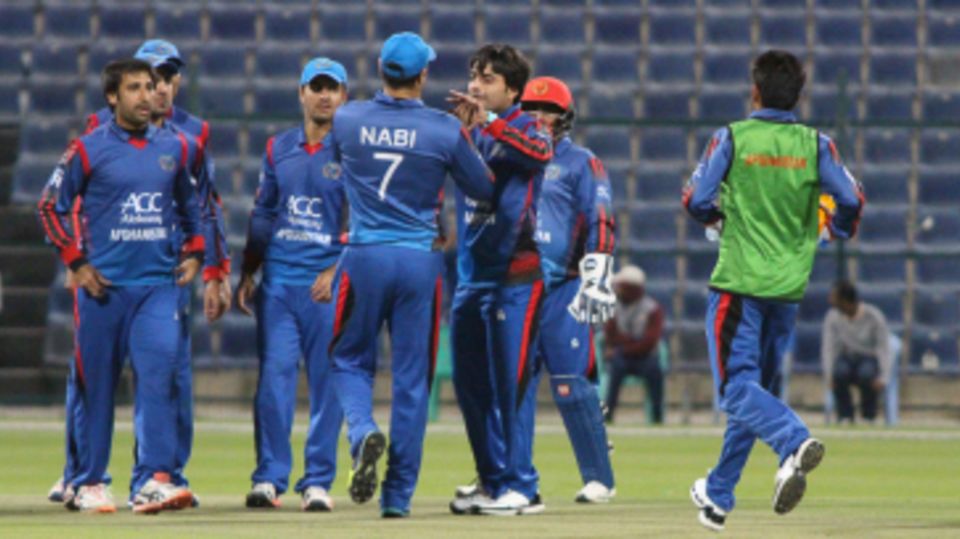 Rashid Khan gets a high five from Mohammad Nabi after dismissing Kevin O'Brien