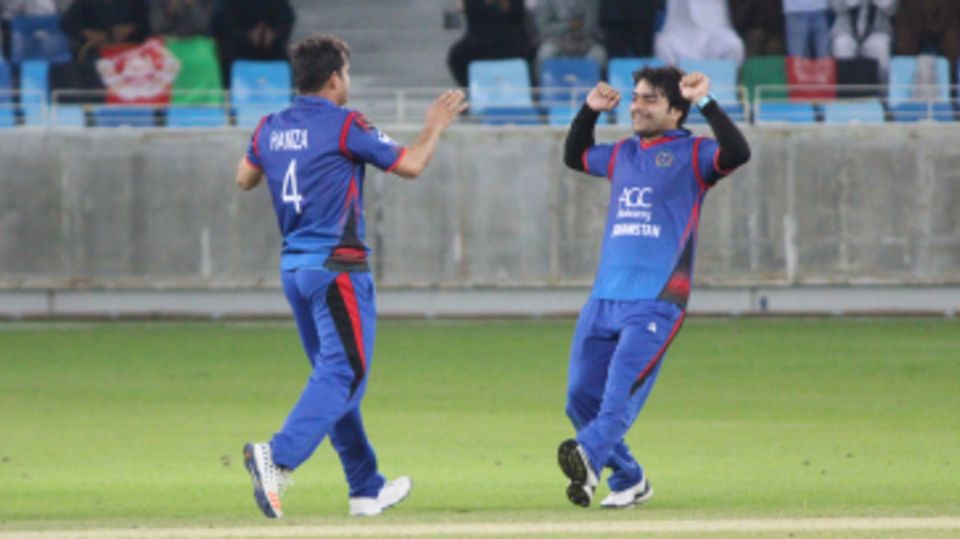 Rashid Khan rushes in to celebrate a wicket with Amir Hamza