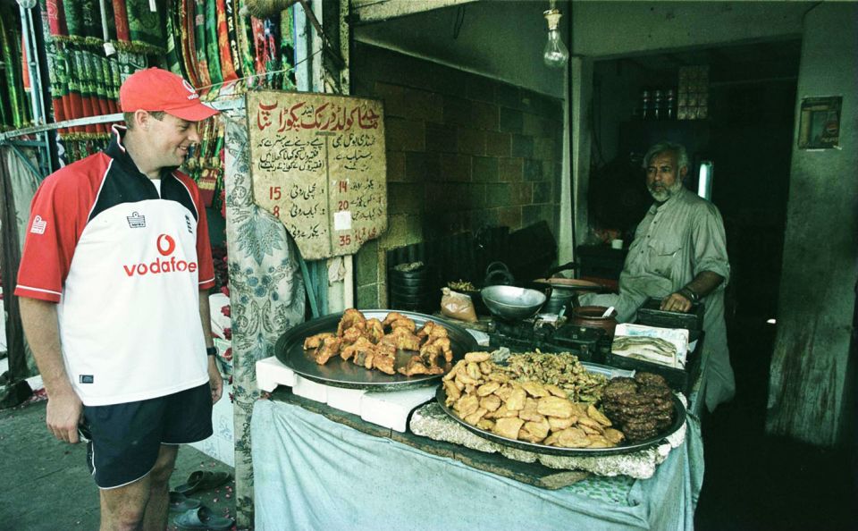 Marcus Trescothick looks at a display of fried food in a market in Karachi