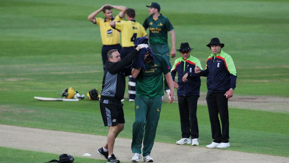 Fletcher is guided from the field at Edgbaston
