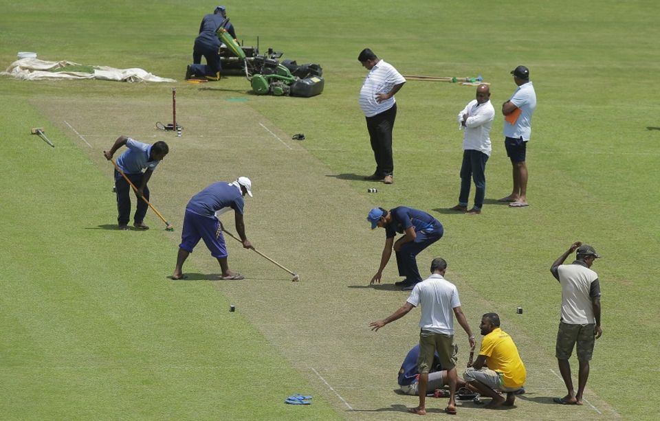 Sri Lanka captain Dinesh Chandimal inspects the pitch even as the groundstaff works on it