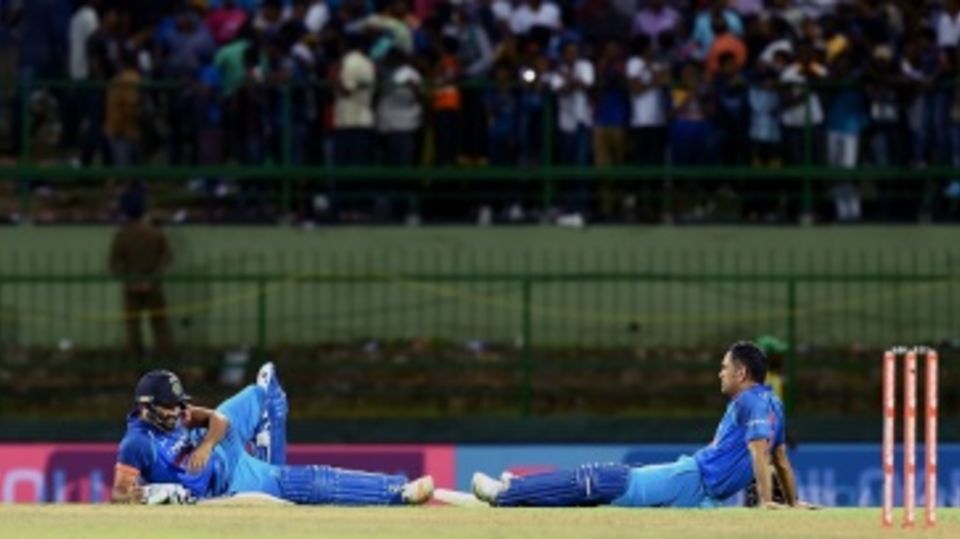 Rohit Sharma and MS Dhoni sit near the pitch as crowd trouble pauses the match