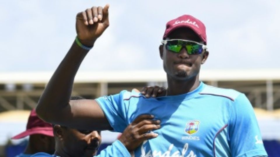 Captain Jason Holder stretches at a training session