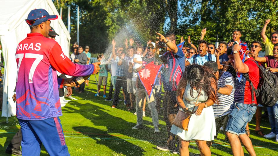 Paras Khadka gives the traveling Nepal fans a champagne shower to celebrate a famous win
