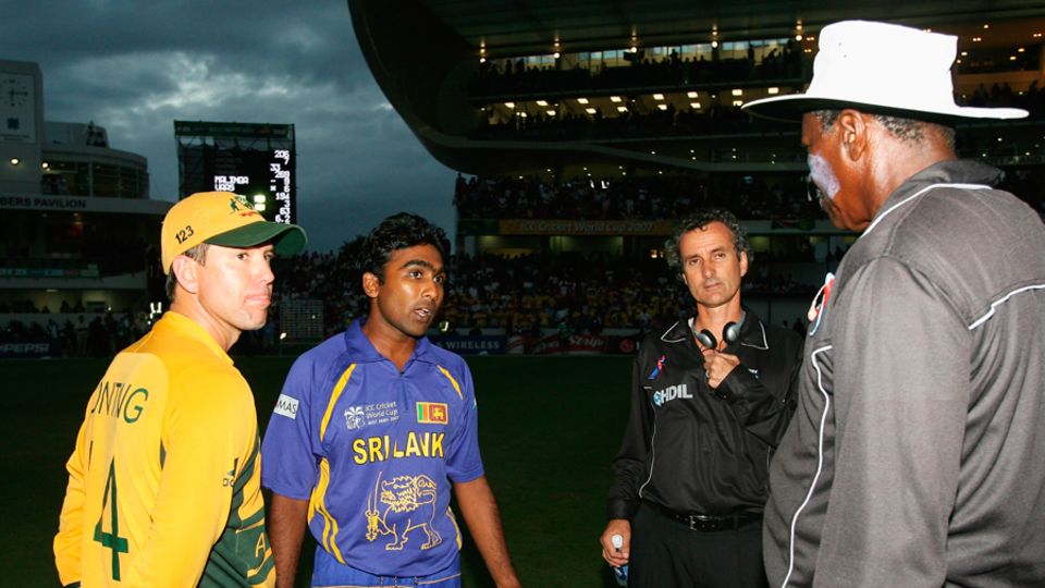 Dimly fades the Cup: the two captains and the umpires discuss the light rules at the dingy end of the final