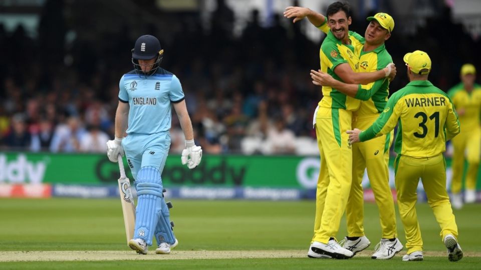 Mitchell Starc celebrates with teammates as Eoin Morgan walks back