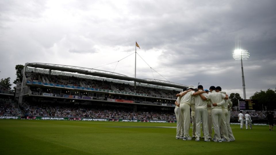 England get together in a team huddle under a gloomy sky