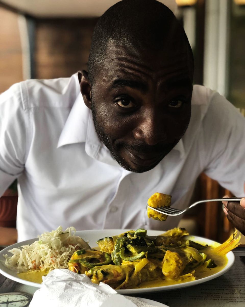 Olando finds a camera phone in his face while he enjoys his coconut fish curry meal