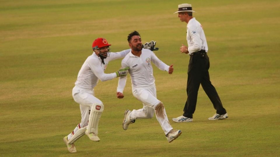 Rashid Khan sets off on a celebratory run, with Afsar Zazai in pursuit, after the last wicket