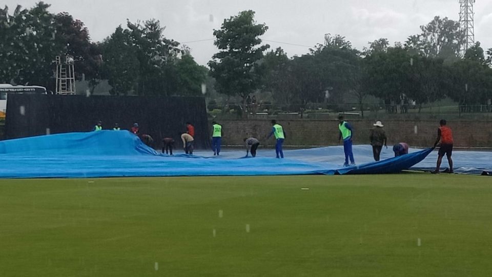 Mumbai players help the groundstaff with the covers