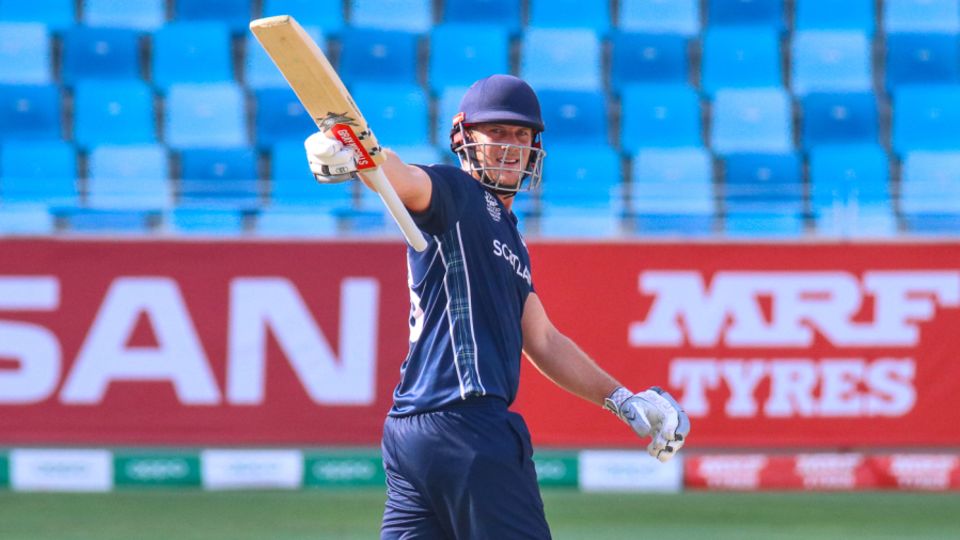 George Munsey raises his bat to the Scotland dugout after reaching a half-century