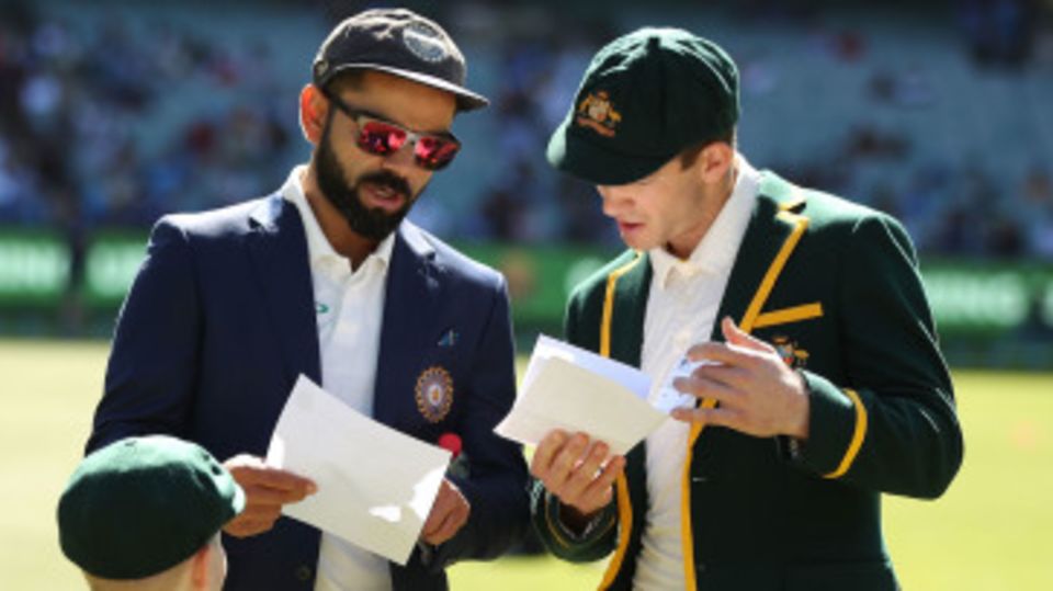 Virat Kohli and Tim Paine exchange team sheets before the coin toss