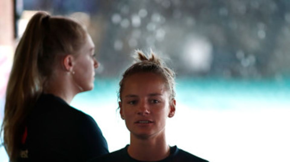 Sarah Glenn and Danni Wyatt wait for the rain to stop