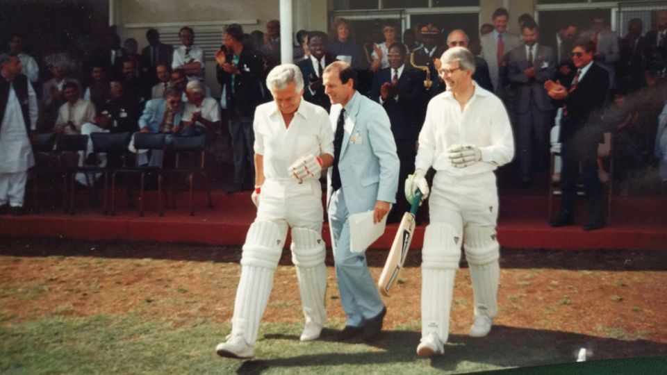 Bob Hawke and John Major walk out to bat. Mark Williams of the British High Commission in Harare is right behind them