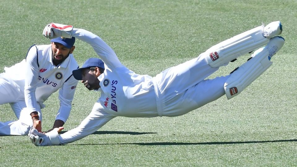 Cheteshwar Pujara and Wriddhiman Saha dive unsuccessfully for a catch