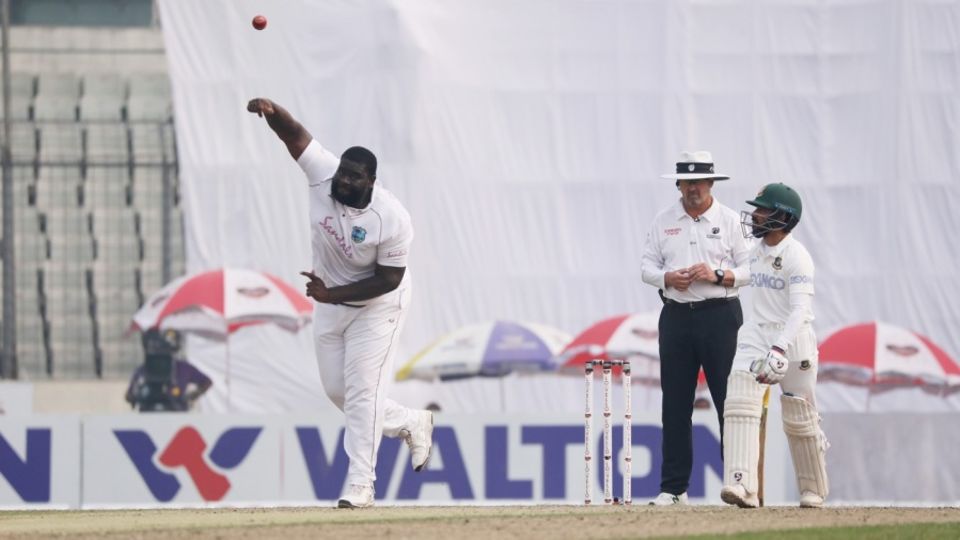 Rahkeem Cornwall tosses one up as Mominul Haque looks on