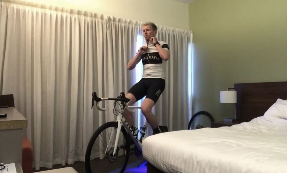 Peter Siddle exercises on a stationary bike in his hotel room during a period of quarantine