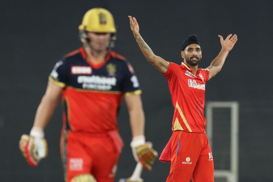 Harpreet Brar's arms are aloft after sending back AB de Villiers