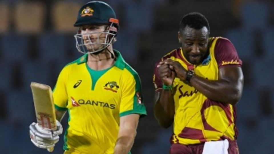 Mitchell Marsh avoids a collision with Andre Russell