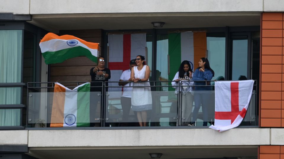 A group of fans watches the Lord's Test from an apartment across the road from the ground